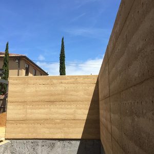 A beautiful rammed earth pool wall